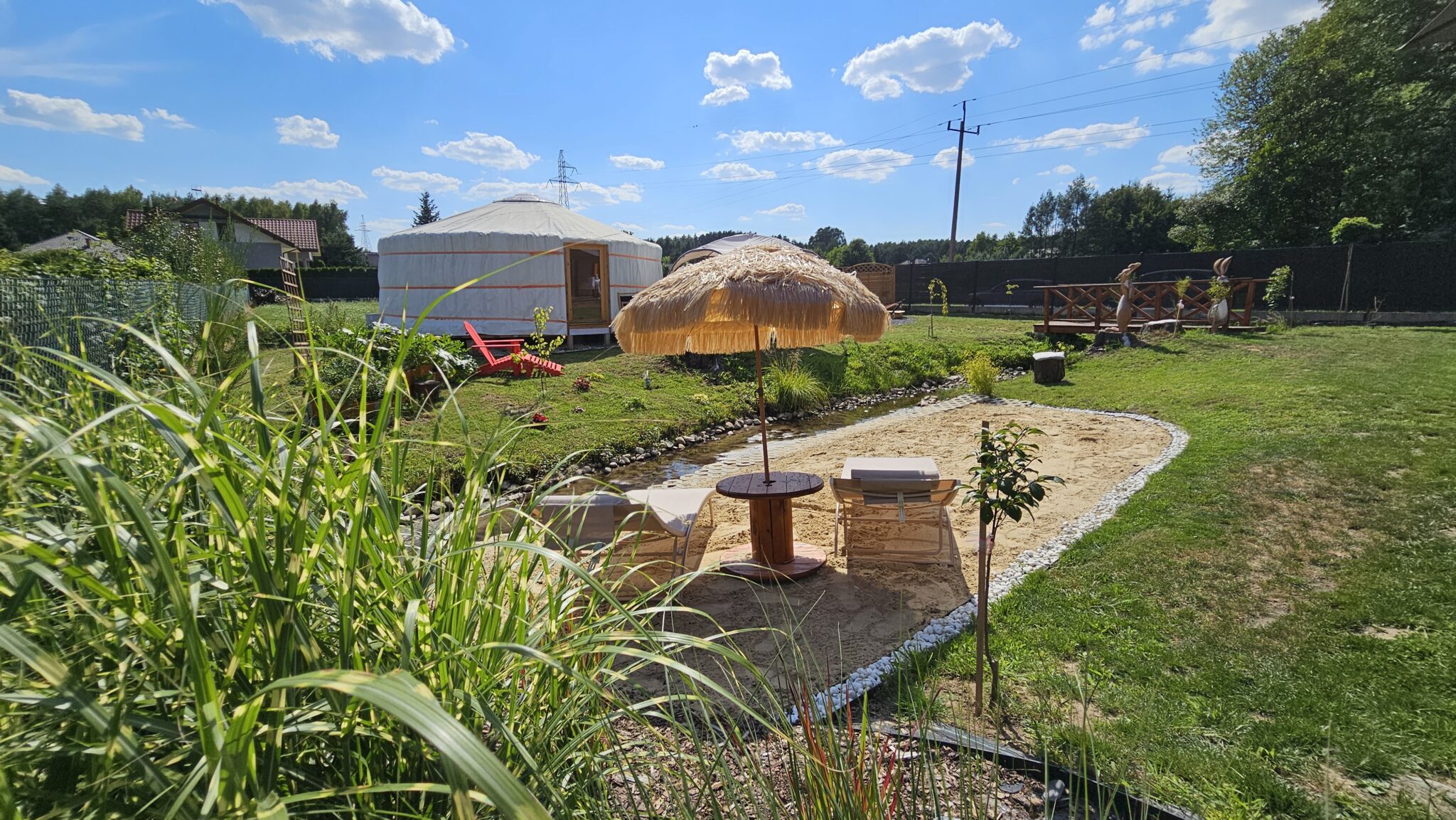 Prywatna plaża nad strumykiem, leżaki i słomiany parasol